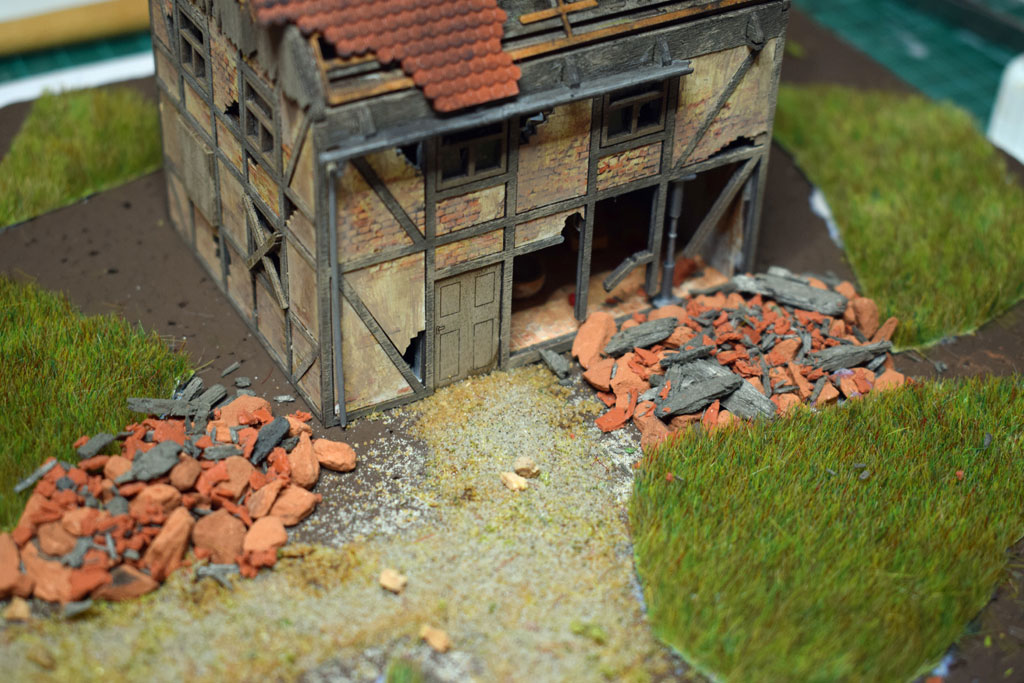 Herabgefallene Dachziegel, Gebälk und Mauerteile.
(Liegen dem Bausatz bei)